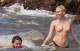 Miley Cyrus smiles while topless in the ocean 