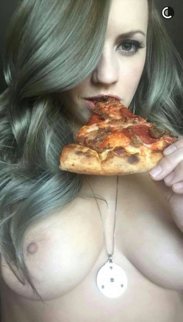 Hot and busty babe eating a slice of pizza
