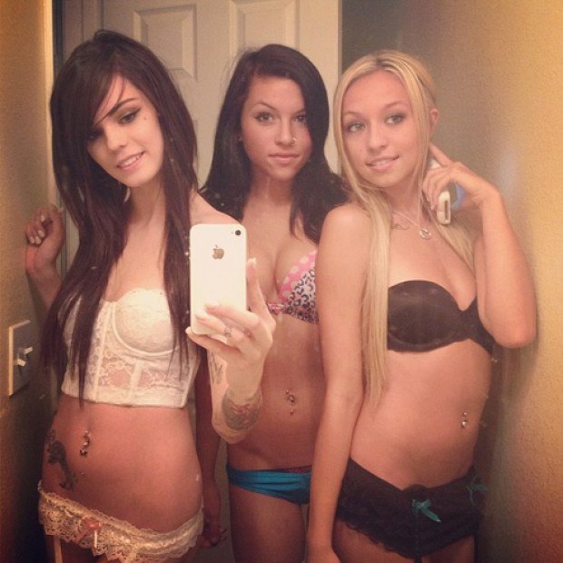 Three sexy teens taking a selfie in the restroom